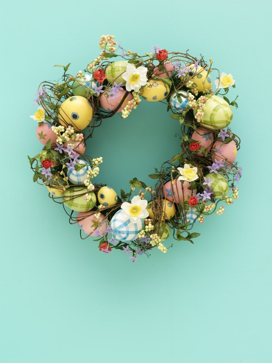 Osterkranz mit bemalten Ostereiern und Frühlingsblumen Osterkranz im Frühlings-Look