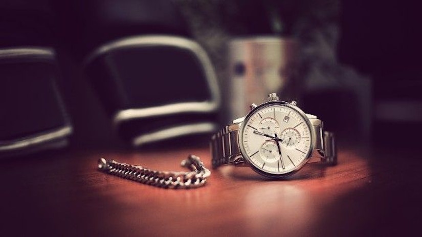 Eine Herrenuhr und ein Armband auf einem Tisch.