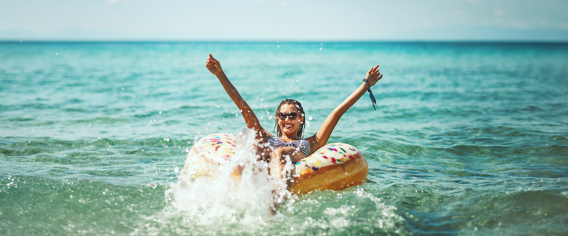 Eine Frau in einem Schwimmdonut im Meer.