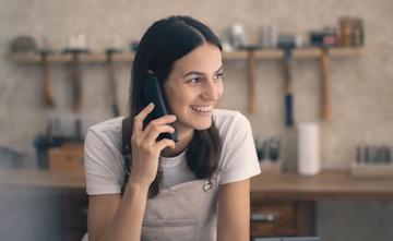 Eine Frau telefoniert und lacht.